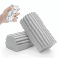 Two gray grooved cleaning sponges, one squeezed with foam