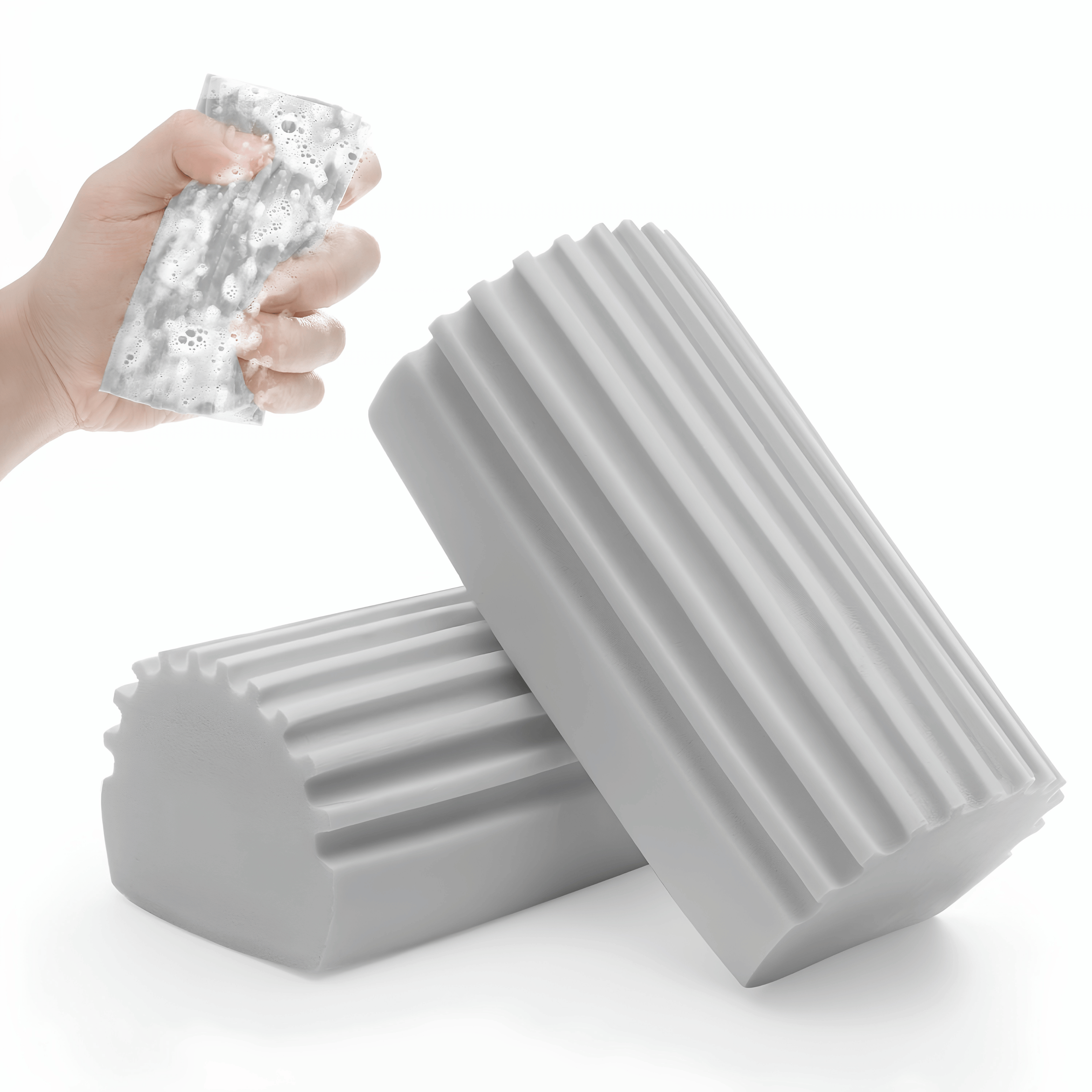 Two gray grooved cleaning sponges, one squeezed with foam